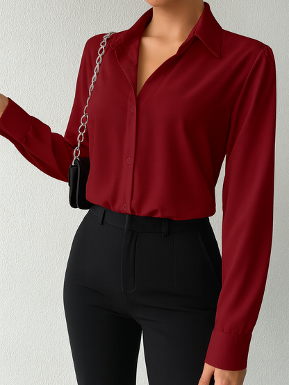 Person wearing a red blouse and black pants against a plain background