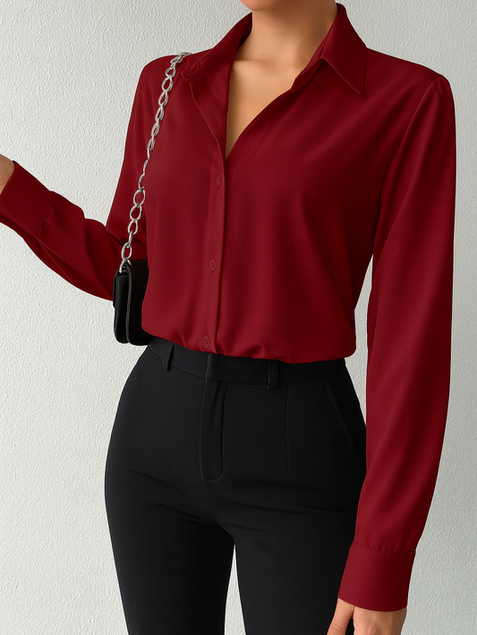 Person wearing a red blouse and black pants against a plain background