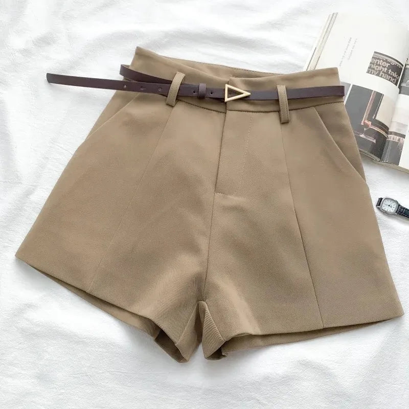 Beige shorts with a belt on a white surface
