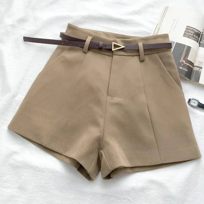 Beige shorts with a belt on a white surface