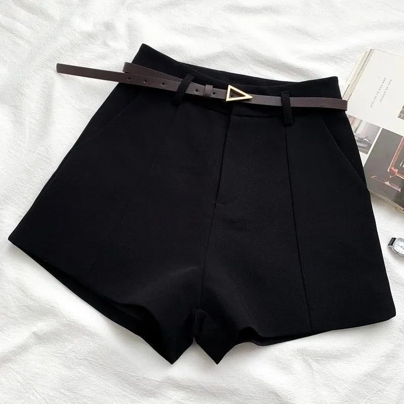 Black shorts with a belt on a white surface